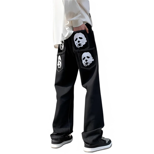 Black pants with white face designs on pockets worn by a person on a white background